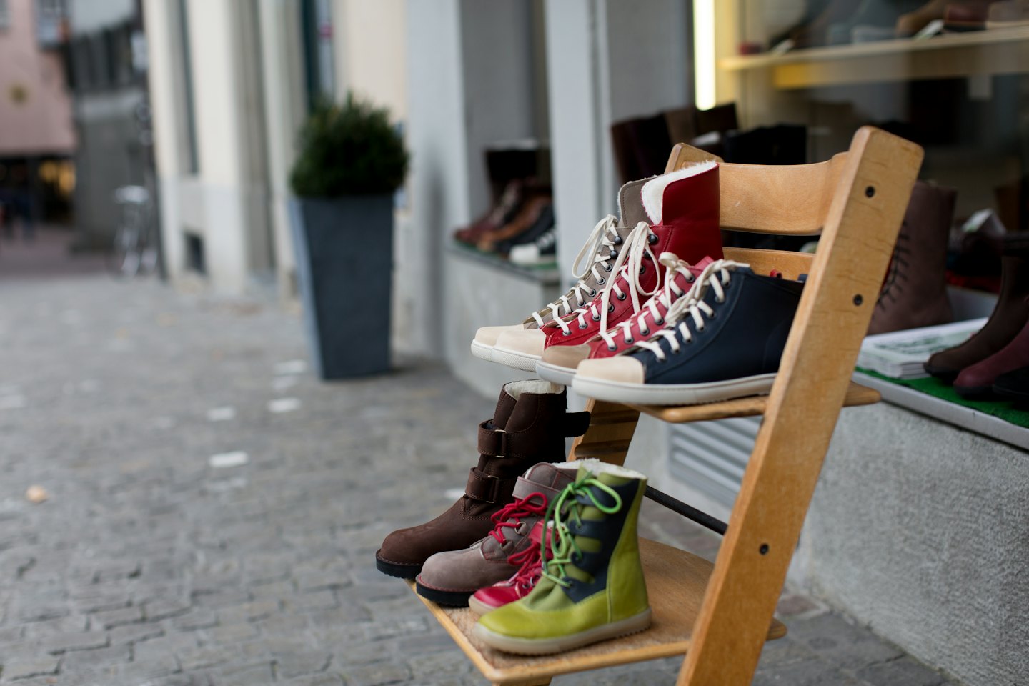 Scarpe da bambino su un espositore di legno fuori da un negozio.